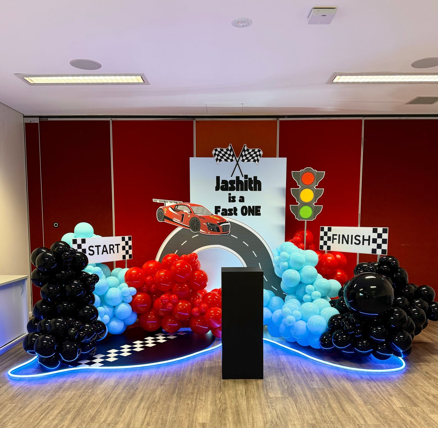 "Kids Race Car Theme Birthday Balloon Package featuring race car-shaped balloons, checkered flag designs, and colorful helium balloons for a fun and exciting birthday celebration
