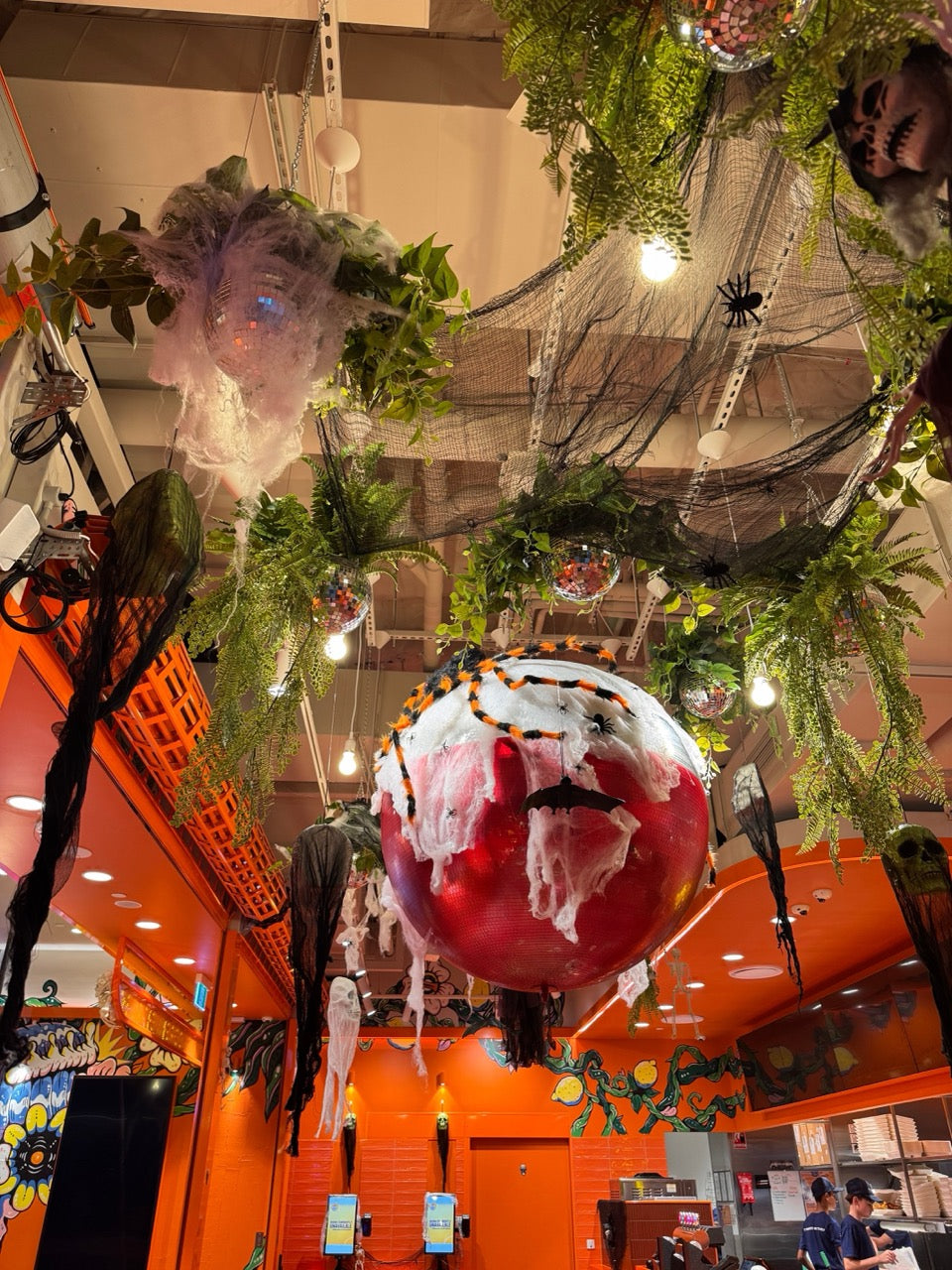 Halloween-themed decorations inside a store with pumpkins and spider webs.
